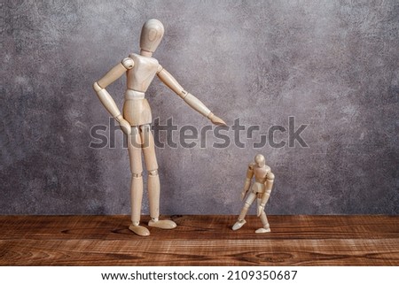 wooden mannequins as adult scolding and intimidating a child