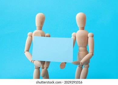 Wooden mannequins with blank poster on color background - Powered by Shutterstock