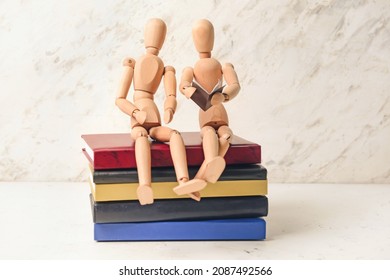 Wooden mannequins with books on light background - Powered by Shutterstock