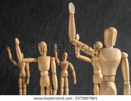 wooden mannequins as obedient subservient people on dark background