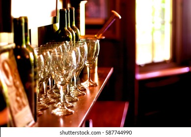 Wooden Mantelpiece With Wine Bottles, Glasses And Mortrar And Pestle. Elegant Fireside In An Old House.