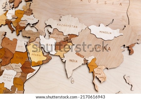 Wooden map of the world on a light background. Self made. Plywood. In beige tones. Asia, Europe, Africa. Eurasia continent. China. Near East. India.