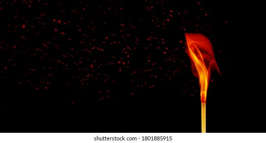 Wooden match stick with fire burning and sparkles in black background.