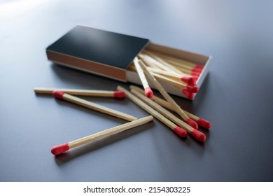 Wooden Matches In A Classic Slide Box With A Red Stick Tip And Side Strike Zone On Grey Background With Dramatic Lighting