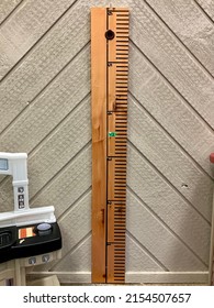 A Wooden Measuring Stick That Is Attached To The Wall. The Ruler Measures Up To 6 Feet In Height. There Is A Marker At 42 Inches.