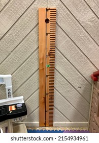 A Wooden Measuring Stick That Is Attached To The Wall. The Ruler Measures Up To 6 Feet In Height. There Is A Marker At 42 Inches.