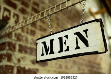 Wooden Mens Room Sign In Front Of A Brick Wall