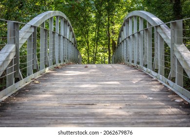 Wooden And Metal Footbridge Through The Woods