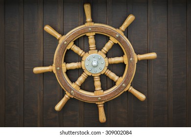 Wooden metal old wheel steering on wood background.