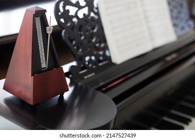 Holzmetronom auf einem alten schwarzen Klavier