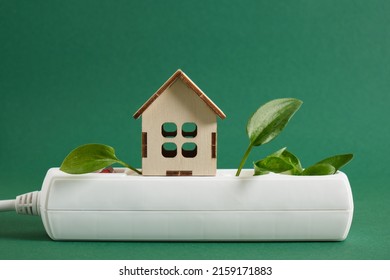 Wooden Miniature House, Green Leaf Plug, Surge Protector, Eco-friendly Electricity For Your Home Green Background