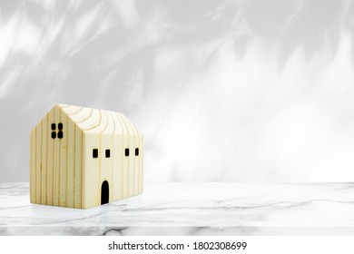 Wooden Miniature House on Marble Table with Tree Shadow on Concrete Wall Texture Background, Suitable for Product Presentation Backdrop, Display, and Mock up. - Shutterstock ID 1802308699
