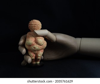 Wooden model hand holding Venus Willendorf replica