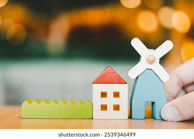 The wooden model house and the windmill house which is a symbol representing clean energy in a good environment. - Powered by Shutterstock