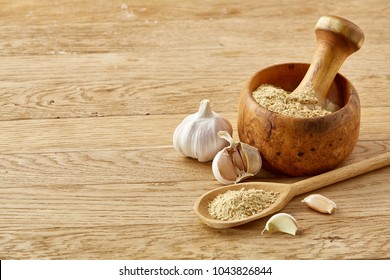 Wooden mortar and pestle with ginger and grind spicies on rustic table, close-up, selective focus - Shutterstock ID 1043826844