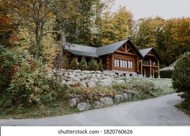 Wooden mountain house built from wood logs. Beautiful log house with porch, patio and driveway in peaceful forest scenery, Canada - Shutterstock ID 1820760626