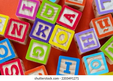 Wooden multicolored blocks with letters on orange background. Education for preschooler, reading, alphabet. Back to school concept	 - Shutterstock ID 2203491271