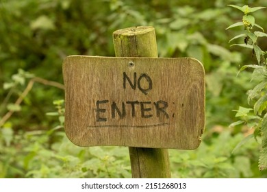 A Wooden No Enter Sign Against Natural Green Leaf Background