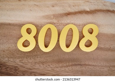 Wooden  numerals 8008 painted in gold on a dark brown and white patterned plank background.