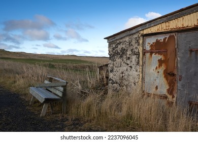 Wooden old abandoned house with a farm, surrounded by a field and pasture. Autumn grass. Blue sky with white clouds. Holmsvollur, Sudurnesjabaer, Iceland. - Shutterstock ID 2237096045