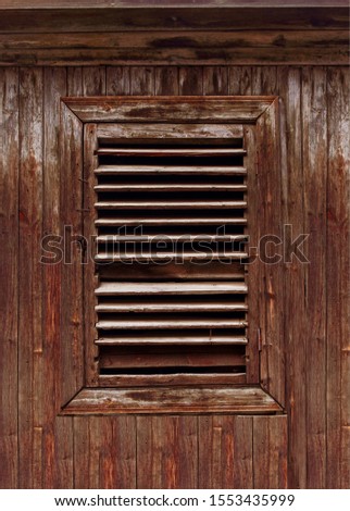 Wooden old shutters close-up. Against the background of the texture of a brown cracked tree.