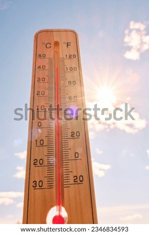 Wooden outdoor thermometer background scorching summer sun and blue sky