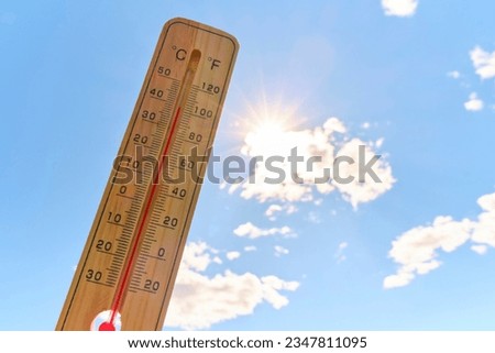 Wooden outdoor thermometer background scorching summer sun and blue sky