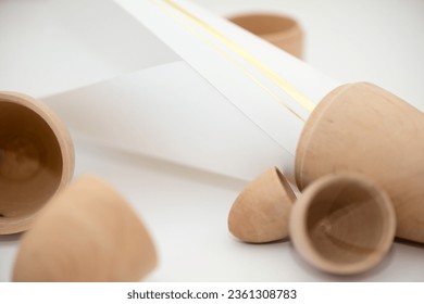 wooden ovoid container objects with paper on a blank surface
