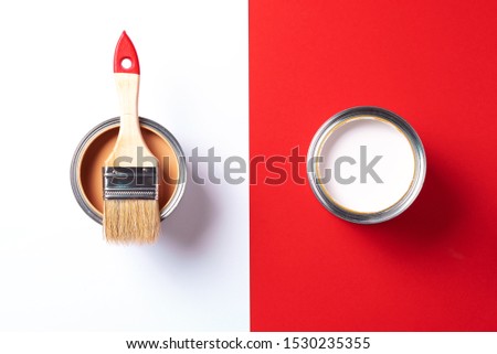 Wooden paint brush, open paint cans on trendy red and white background. Top view, copy space. Appartment renovation, repair, building and home design concept