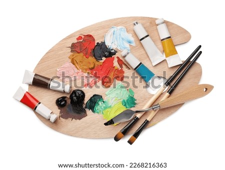 Wooden palette with oil paints and tools on white background, top view