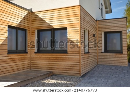 Wooden Paneles natural modern new house with windows in summer sunny day