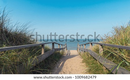 Wooden path at north sea over sand dunes with ocean view