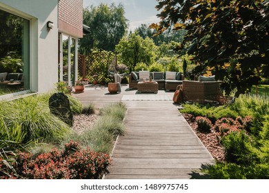 Wooden path to terrace in the garden with trendy garden furniture