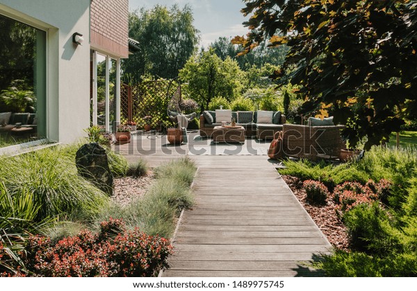 Wooden path to terrace in the garden with
trendy garden furniture