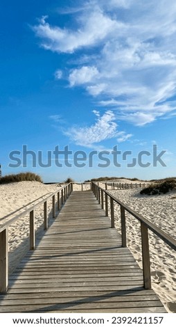 Wooden Pathways by the Atlantic Ocean. Costa de Prata, Portugal. Wooden walkway leading to the beach with blue sky and white clouds.  [[stock_photo]] © 