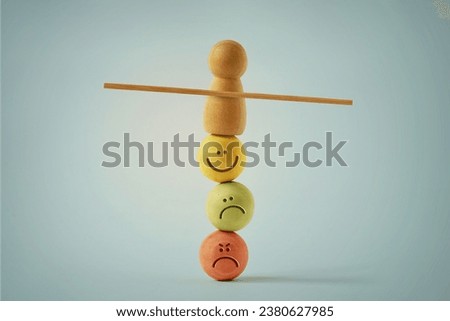 Wooden pawn balancing on beads faces with different mood expressions - Concept of emotional and mental balance