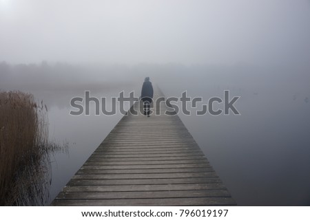 Wooden pedestrian bridge into the baltic sea on a goggy day in spring
