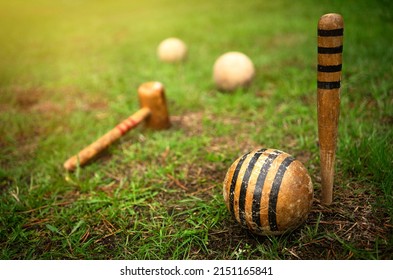 Wooden pegs for playing croquet.The rays of the sun over the green grass.