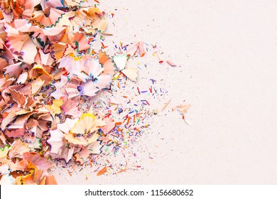 Wooden pencil shavings and colorful crumbs of graphite from sharpener on soft pink pastel paper background. Top view. Design elements for poster, banner, cards. - Powered by Shutterstock