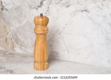 Wooden Pepper Grinder Over Marble