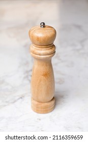 
Wooden Pepper Grinder Over White Marble