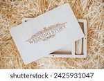 Wooden photo box for photo storage on straw background. Open Box with flash with laser engraving "wedding story" set for the photographer, presentable set of photos, luxury feedback to client.