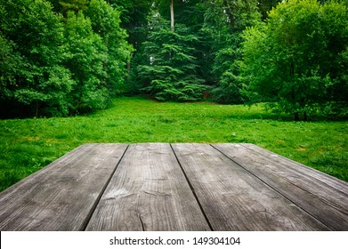 Wooden Picnic Table With Green Nature Background