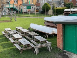 Wooden Picnic Tables Near Boats Stored Outdoors At Boat Club