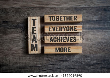 Wooden pieces with Team - Together everyone achieves more on wooden background