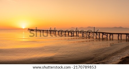 Wooden pier in the beach. Wood bridge in the beach. Sunset in the beach, golden hour. Mallorca island, 