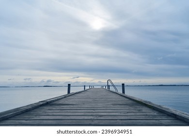 Wooden pier or dock on sea water in morning light in Sweden - Powered by Shutterstock