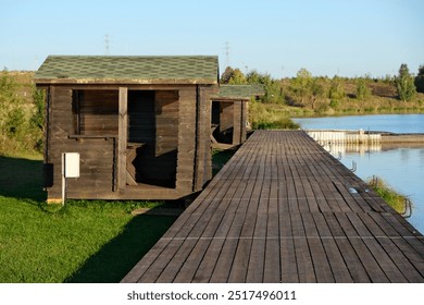 wooden pier with a gazebo on the lake shore - Powered by Shutterstock