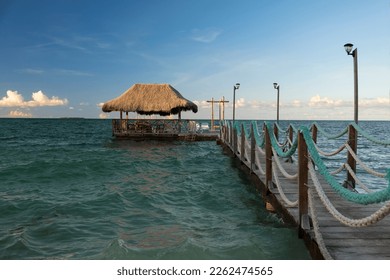 Wooden pier going far into the ocean with a boat dock at the end, Rosario Islands, Cartagena, Colombia. Shot in early morning, blue sky, sunny day. - Powered by Shutterstock