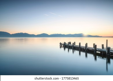 Wooden pier or jetty and lake at sunrise. Torre del Lago Puccini, Versilia, Massaciuccoli lake, Tuscany, Italy, Europe